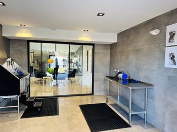 a living room with a desk and a large glass door